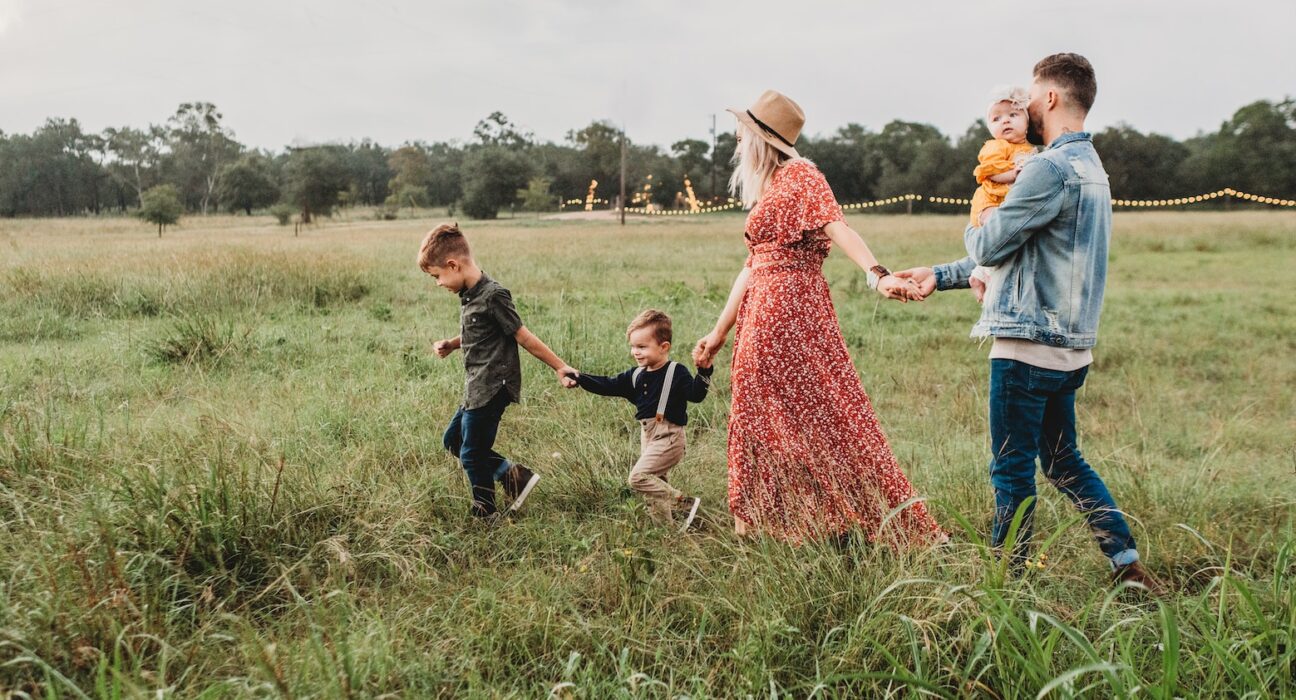 woman holding man and toddler hands during daytime