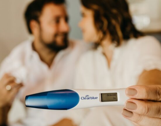 man in white dress shirt holding blue and white digital thermometer