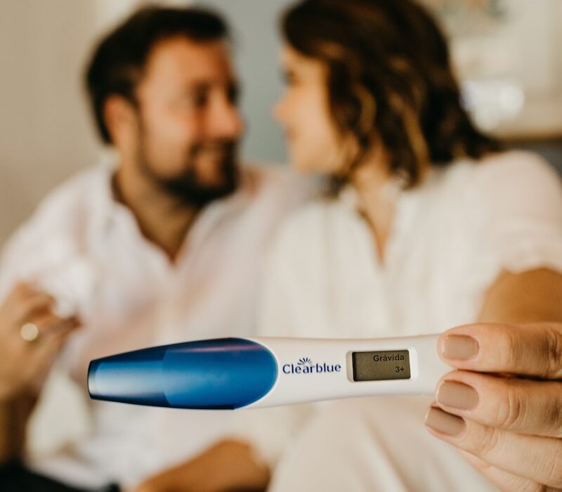 man in white dress shirt holding blue and white digital thermometer