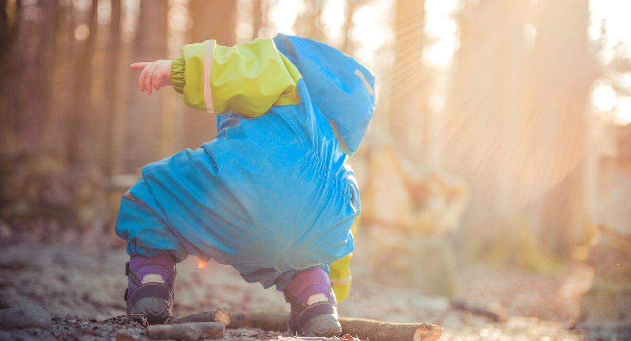 toddler picking up tree branch