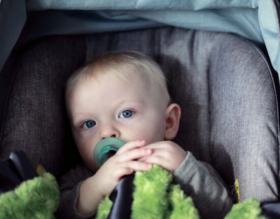 baby on gray stroller