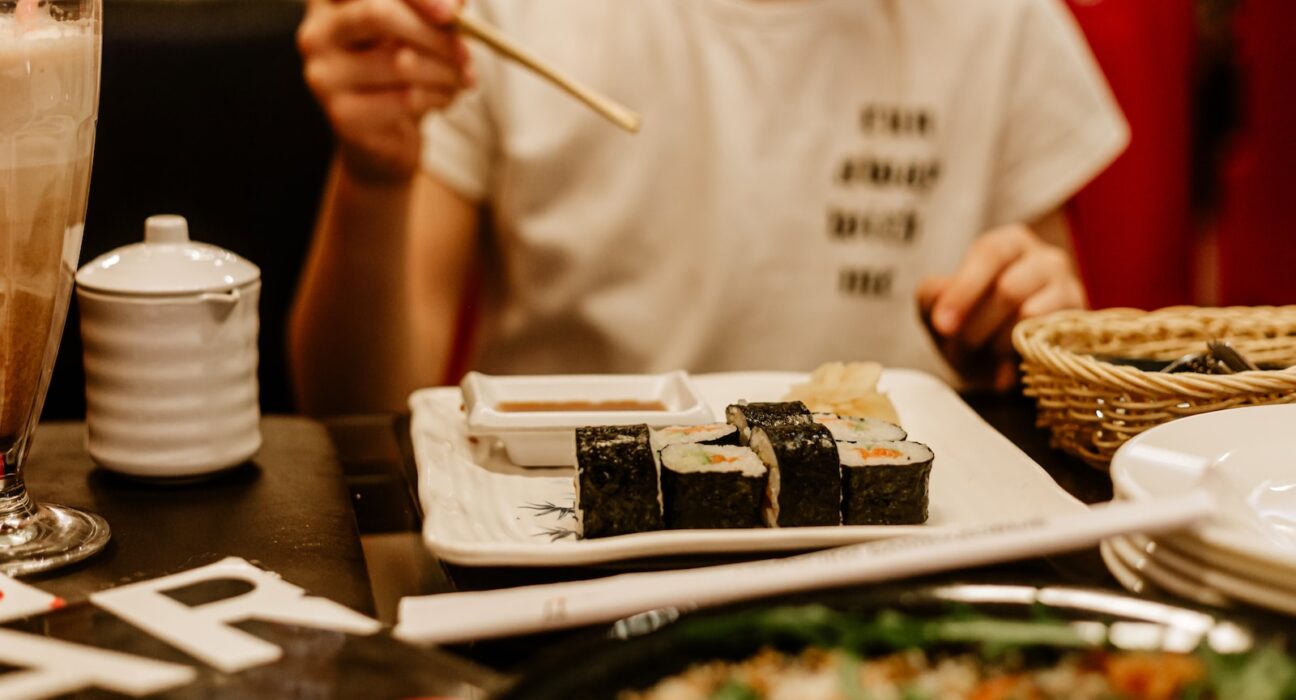 a person sitting at a table with a plate of food