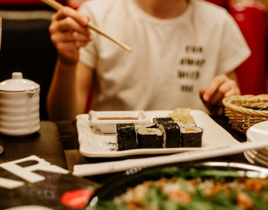 a person sitting at a table with a plate of food