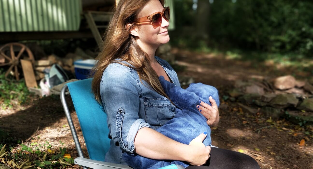 woman carrying baby while sitting on chair