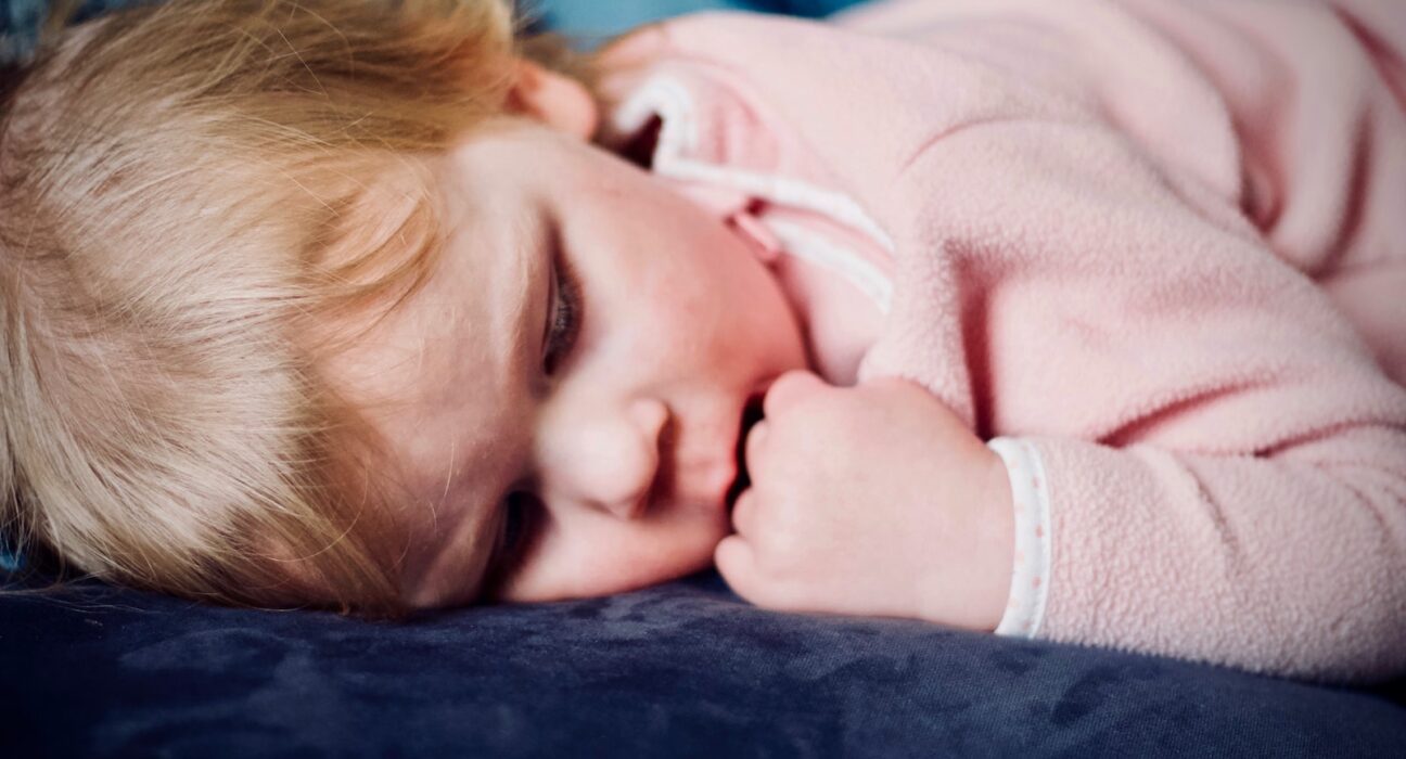baby sleeping on black surface