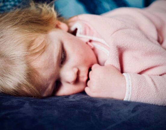 baby sleeping on black surface